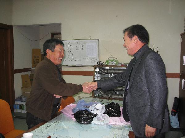 1210_안종철씨가_허기연_내가면장에게_동전을_전달하고_있다