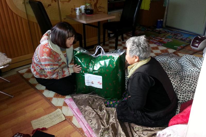 강화군장애인종합복지관에서_이불을_전달하고_있다