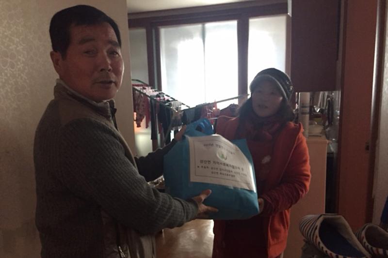 삼산면_지역사회보장협의체에서_방한복을_전달하고_있다