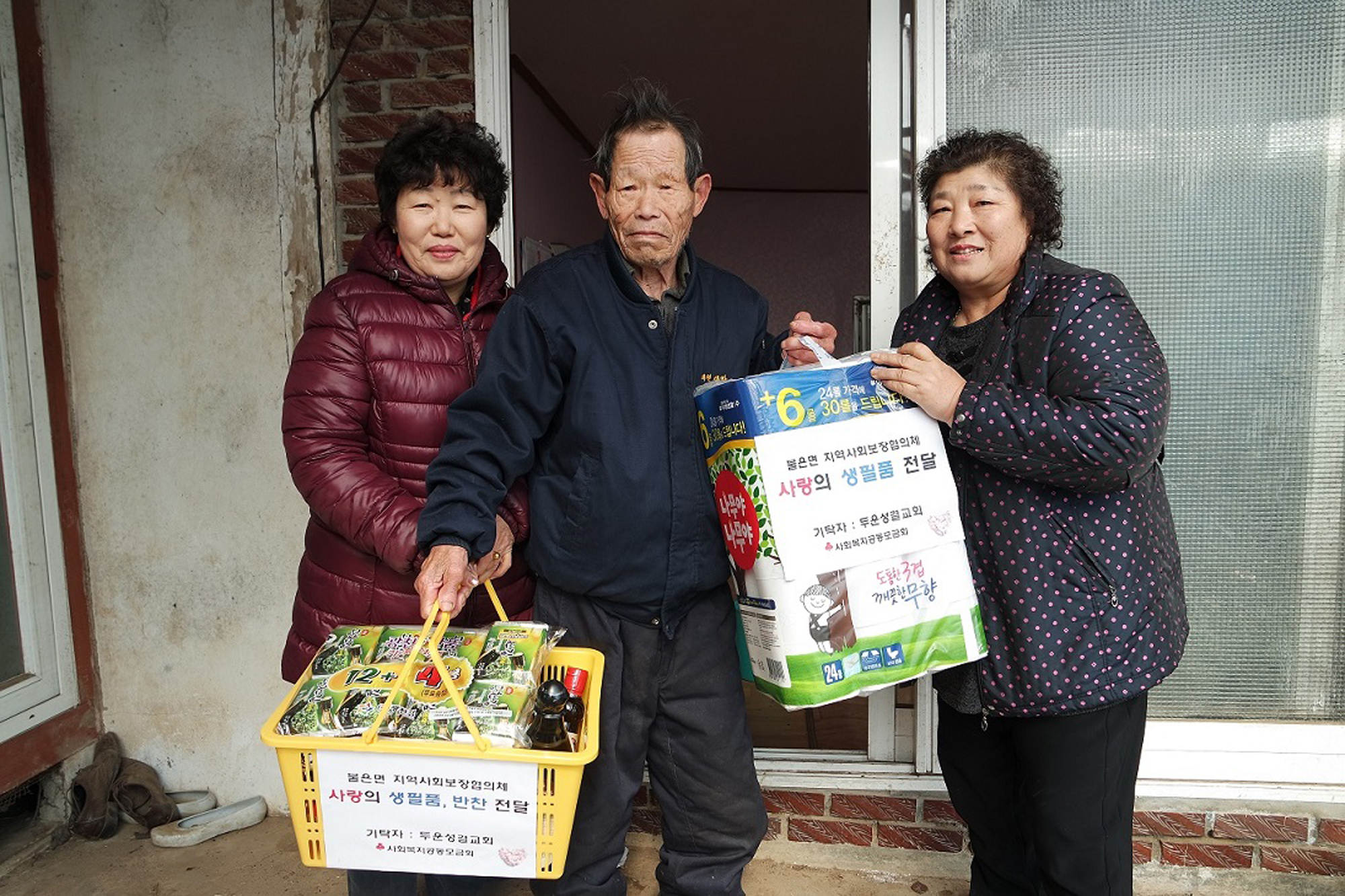 불은면_지역사회보장협의체_위원들이_어려운_어르신에게_직접_만든_반찬과_생필품을_전달하고_있다