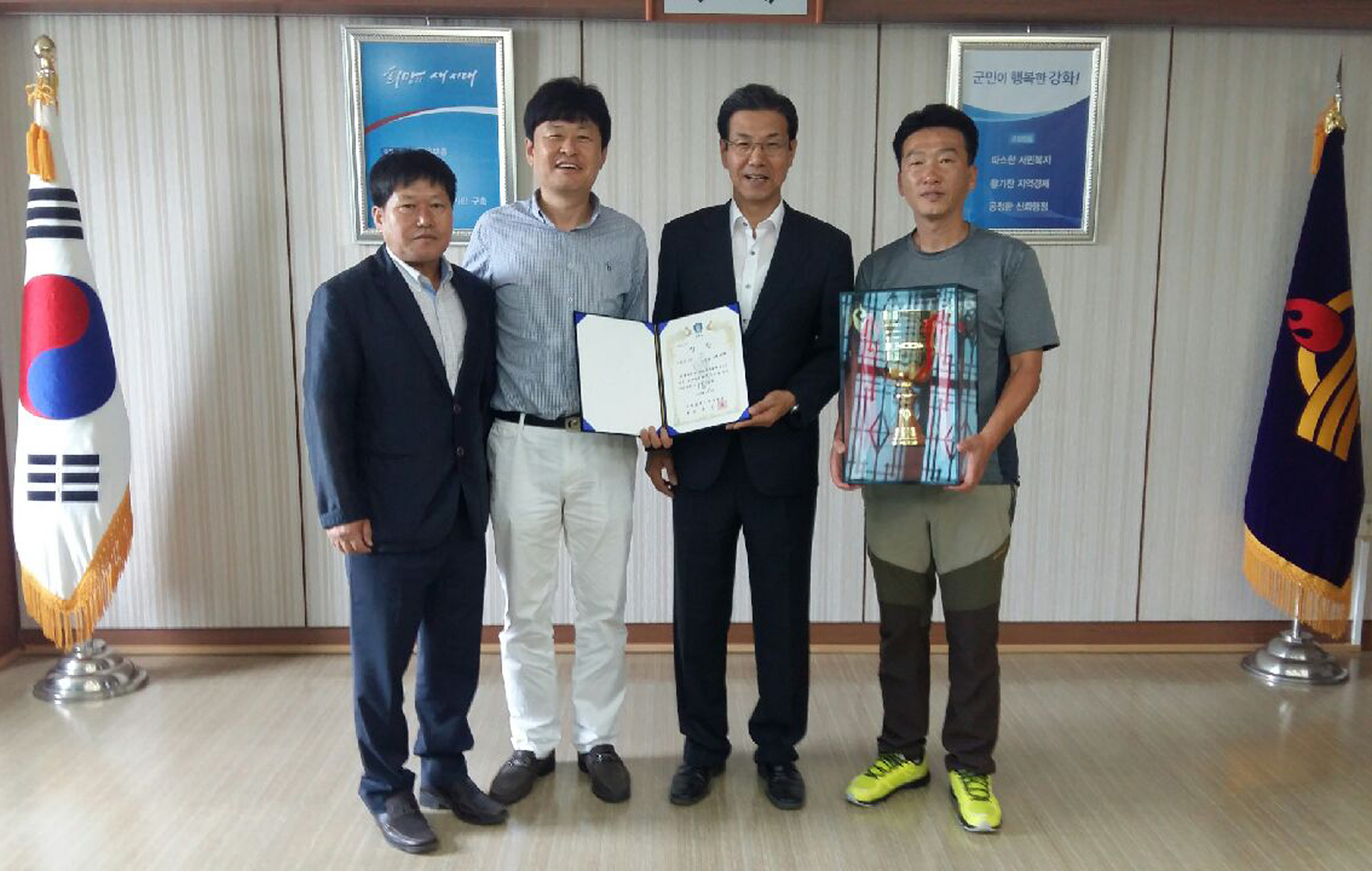 이상복_군수가_강화_유소년팀_관계자와_우승트로피를_들고_기념_촬영을_하고_있다
