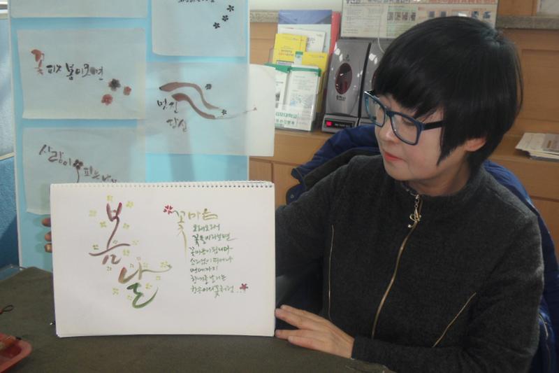 안병미_강사가_직접_쓴_캘리그라피를_들고_있다
