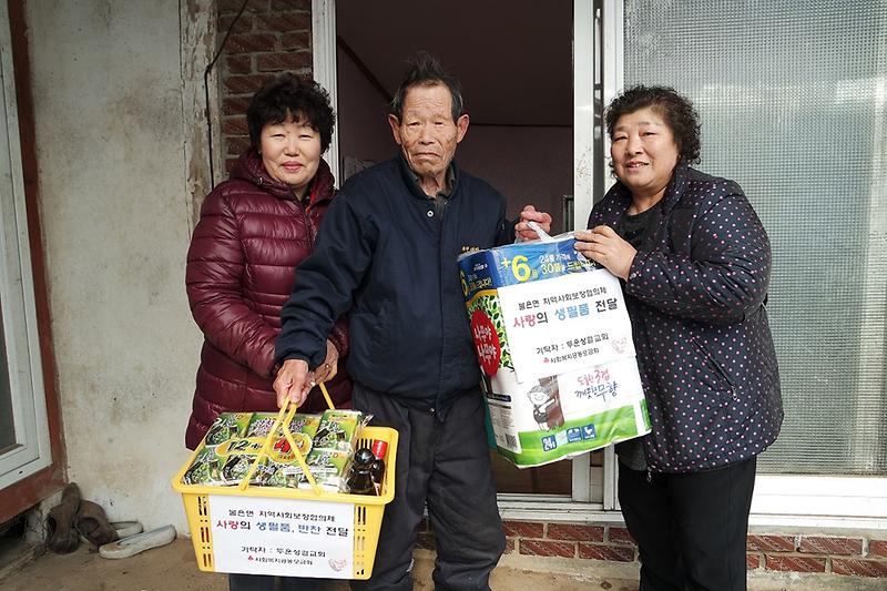 불은면_지역사회보장협의체_위원들이_어려운_어르신에게_직접_만든_반찬과_생필품을_전달하고_있다