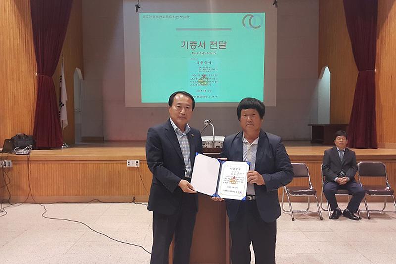 체육진흥후원회장이_동광중학교장에게_기부증서를_전달하고_있다1