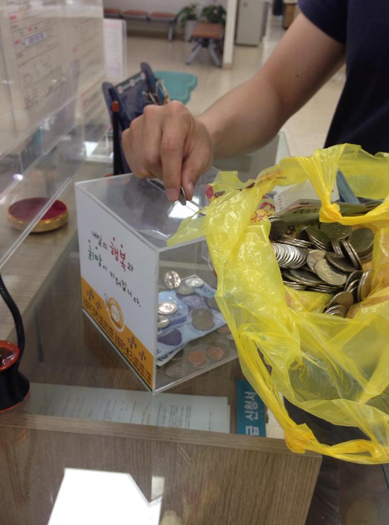 동전을_모금함에_기부하고_있다