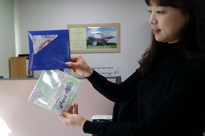 강화군청_직원이_소창으로_만든_손수건과_행주를_들고_있다