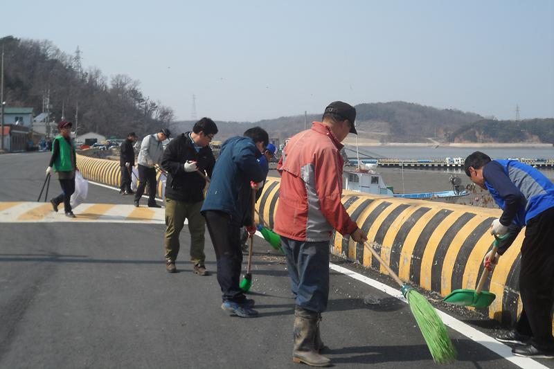 해안가_도로변에_방치된_쓰레기를_청소하고_있다