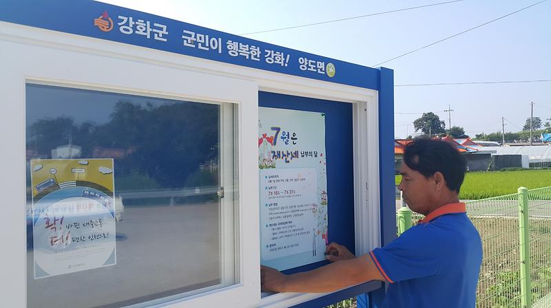 양도면_건평리의_이장이_군정소식게시판에_홍보물을_게시하고_있다