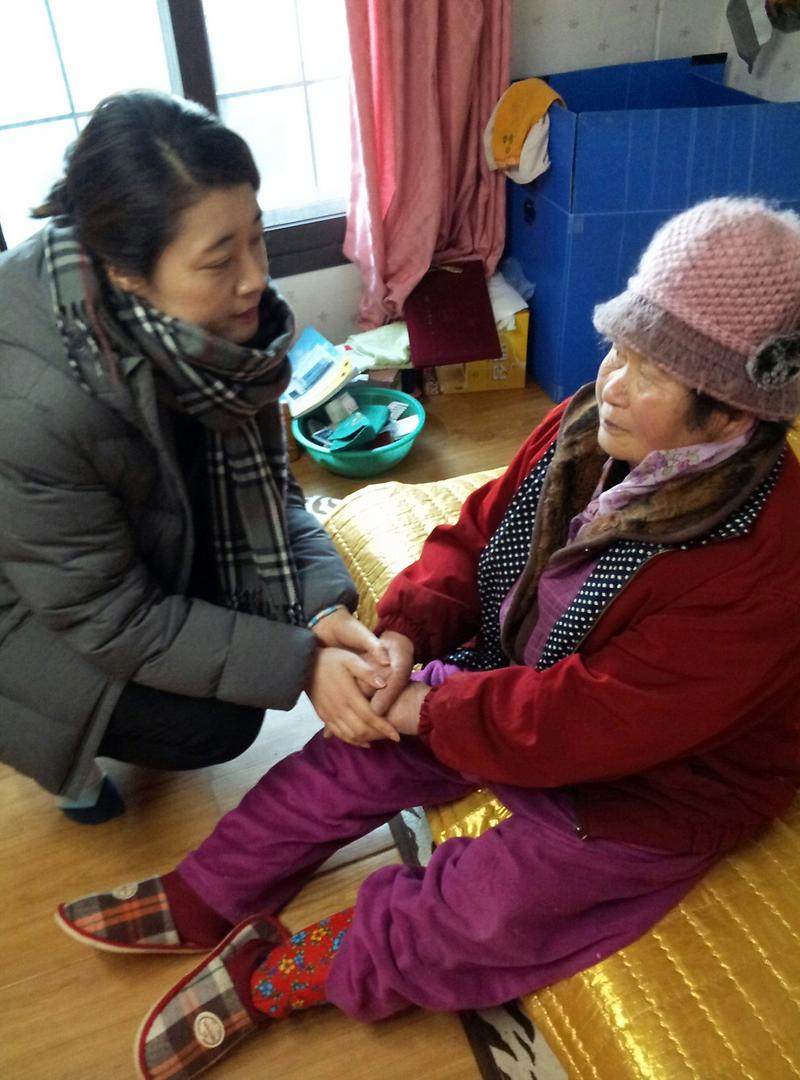 사회복지사가_어르신께_기름_구입비를_전달하고_손을_꼭_잡고_있다